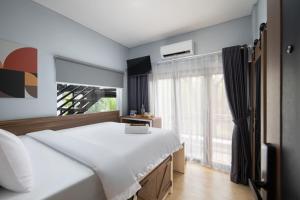 a bedroom with a large white bed and a window at Cove Good Friends in Busuk 1 +13 photos