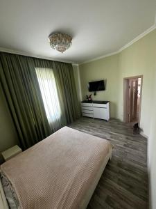a bedroom with a large bed and a chandelier at Арендное жилье Лиманка in Odesa