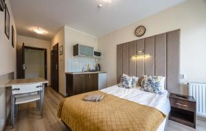 a bedroom with a bed and a desk and a clock at Villa Laguna in Rowy