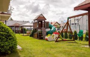 a playground with a slide and a play structure at Villa Laguna in Rowy