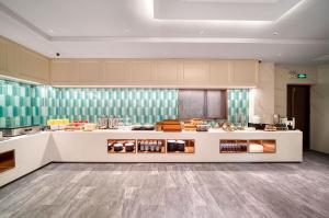 a large kitchen with a counter in a room at Ibis Styles Liyang Shanghecheng in Liyang