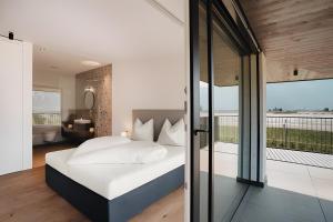 a bedroom with a bed and a balcony at New Opening Grafferhof in Bolzano