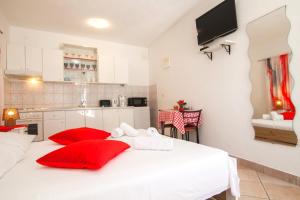 a bedroom with a white bed with red pillows at Old Town Accommodation in Bol +22 photos