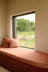 a bed in a room with a large window at Oseraie Cabins - Wild lodges entre Liège et Maastricht in Visé