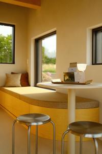 a bedroom with a bed and two stools at Oseraie Cabins - Wild lodges entre Liège et Maastricht in Visé