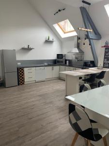 a large kitchen with white cabinets and a skylight at Au Ptit MARIUS in Fécamp +10 photos
