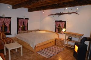 ein Schlafzimmer mit einem großen Bett und einem Sofa in der Unterkunft Drevenička Jakubko in Terchová