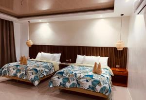 two beds in a hotel room with two beds sidx sidx sidx at Central 1 Suites in Mambajao
