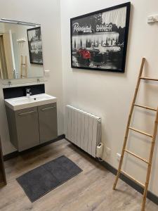 a bathroom with a sink and a mirror at Au Ptit MARIUS in Fécamp