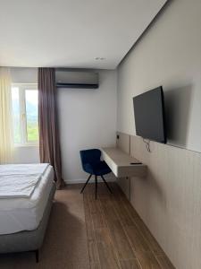 a bedroom with a bed and a desk with a tv at Sliv in Vinica