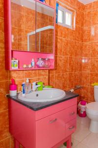 a bathroom with a red sink and a toilet at Hospedaria Santo António 2 in Praia Baixo