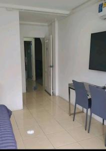 a room with a table and chairs and a tv at Huskies and Company in Pattaya +2 photos