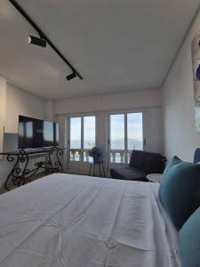 a bedroom with a bed and a couch and a tv at Suite con Vista a las Islas Cies in Vigo +7 photos