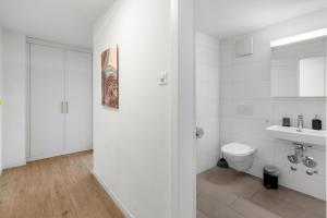 a white bathroom with a toilet and a sink at AirHosted - Lucerne City Centre in Lucerne +98 photos