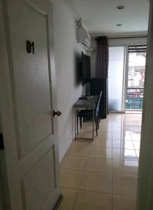 a door leading to a room with a desk and a piano at Huskies and Company in Pattaya