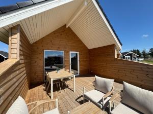 a wooden deck with a table and chairs on it at Løkken Klit GLAMPING in Løkken