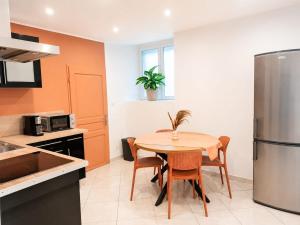 a kitchen with a table with chairs and a refrigerator at Studio Cosy tout équipé 40m2 - Entrée autonome - Parking gratuit in Distroff +5 photos