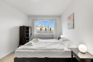 a white bedroom with a large bed and a window at AirHosted - Lucerne City Centre in Lucerne