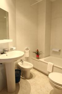 a bathroom with a sink and a toilet and a tub at Hotel Jr in Villalonga