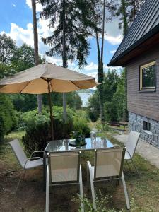 a patio table with an umbrella and two chairs at Mezi Smrky in Bohostice