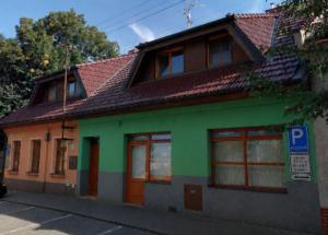 a green and orange building with a parking sign in front at PoBytPodivín in Podivín