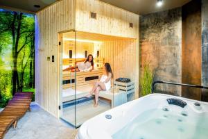 two women sitting in a bathroom with a tub at Resort Pod Lasem in Kolonowskie +45 photos
