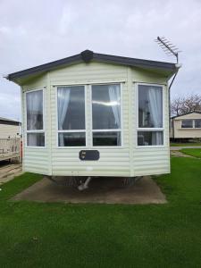 a green house with a large window in a yard at The Joanack Breeze in Withernsea