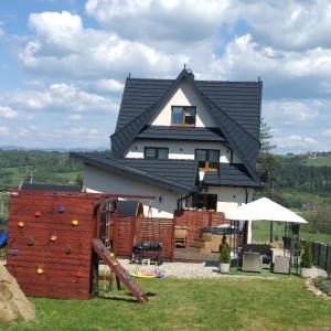 a house with a play yard with a playground at Apartamenty QUER SPA Jacuzzi i Sauna in Bańska Niżna