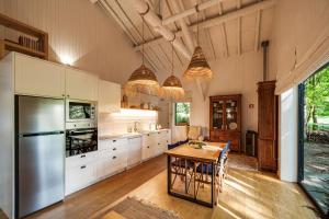 a large kitchen with a table and a refrigerator at Quinta Lamosa Agroturismo in Arcos de Valdevez