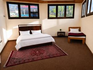 a bedroom with a large bed and a red rug at Blue Bird Resort Utror Swat in Utrot +29 photos