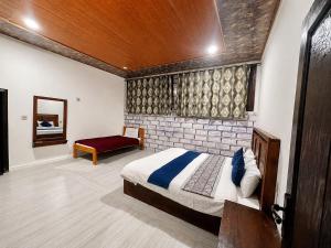 a bedroom with a bed and a brick wall at Blue Bird Resort Utror Swat in Utrot