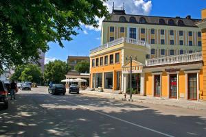 a street with a yellow building on the side of a road at Danube Hotel & Spa in Silistra