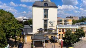 a large white building with a clock tower at Danube Hotel & Spa in Silistra