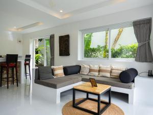a living room with a couch and a table at Cosi Flat & Pool - Chaweng Area in Chaweng