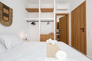 a bedroom with a white bed with towels on it at Proper Stone Villa - Antiparos in Agios Georgios