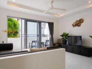 a living room with a couch and a tv at Cosi Flat & Pool - Chaweng Area in Chaweng