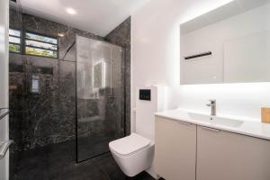a bathroom with a toilet and a sink and a shower at Peperu Lodge - bungalow piscine privée in Punaauia