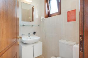 a bathroom with a sink and a toilet and a mirror at Hotel Aristotelis in Ancient Epidauros +17 photos