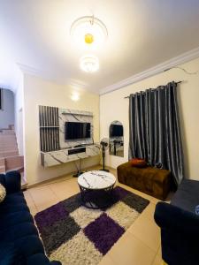 a living room with a couch and a tv at PeaceNest in Idowu +12 photos