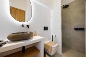 a bathroom with a sink and a mirror at Proper Stone Villa - Antiparos in Agios Georgios +31 photos