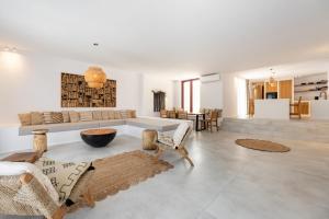 a large living room with a couch and chairs at Proper Stone Villa - Antiparos in Agios Georgios