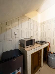 a kitchen with a microwave on top of a counter at PeaceNest in Idowu