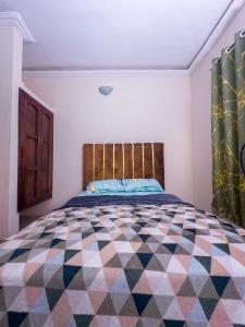 a bedroom with a bed with a colorful quilt on it at PeaceNest in Idowu