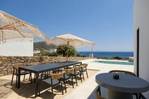 a table and chairs with a view of the ocean at Proper Stone Villa - Antiparos in Agios Georgios