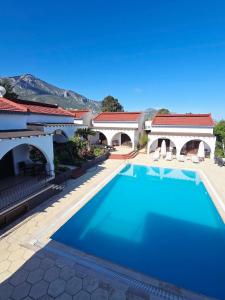 a large swimming pool in front of a house at Five Fingers Holiday Bungalows in Kyrenia