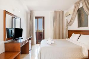 a hotel room with a bed and a television at Hotel Aristotelis in Ancient Epidauros