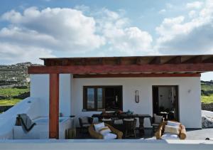 a view of a house with chairs and a table at Ktima Lipsi, Panorama Pool Views in Klouvas