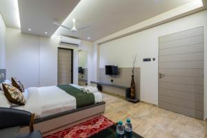 ein Schlafzimmer mit einem Kingsize-Bett und einem Fernseher in der Unterkunft Hotel Gold Star in Rajkot