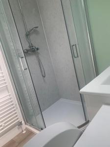 a shower with a glass door in a bathroom at Greenkeepers Rest in Longniddry +15 photos