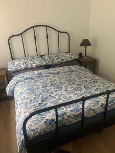 a bedroom with a bed with a blue and white comforter at Greenkeepers Rest in Longniddry